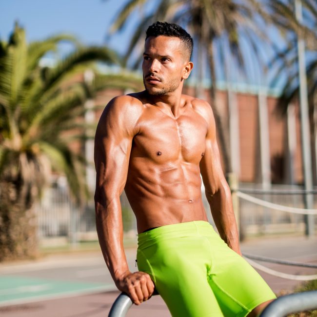 Barechested muscular man exercising outdoors looking around
