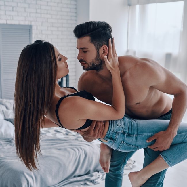 Moments of intimacy. Beautiful young couple embracing while standing in the bedroom