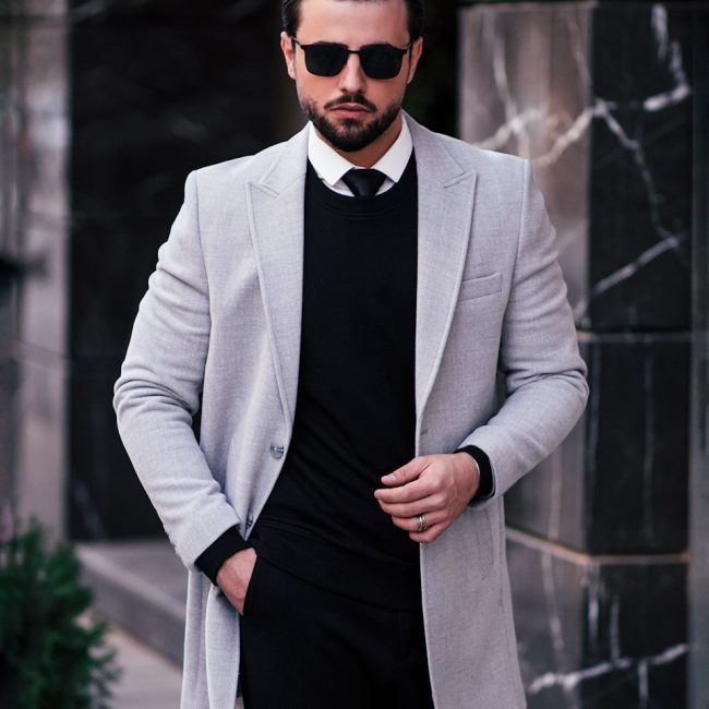 a man in a suit and tie standing on a sidewalk